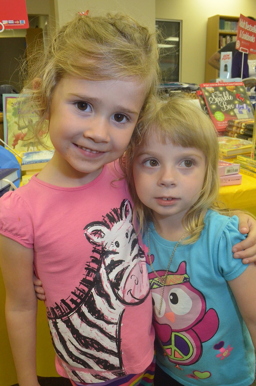Emma Stovall, 4, and her pal Kelsey Mae Burroughs, 4, browse through books together.