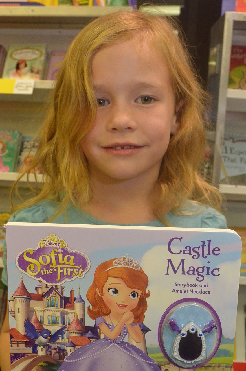 Sydney Brandon, 5, decides between two books to purchase.