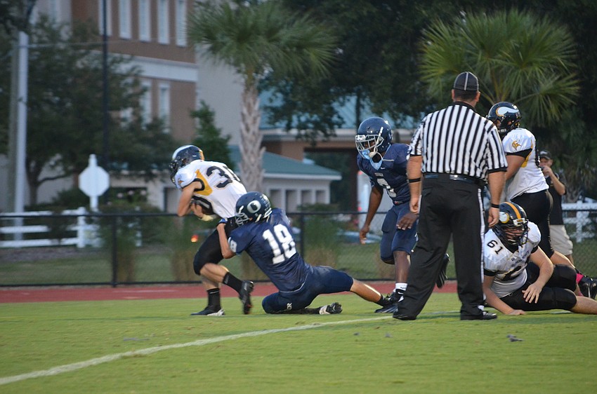 Wide receiver Joseph Runge holds back Bishop Verot from getting a touch down.
