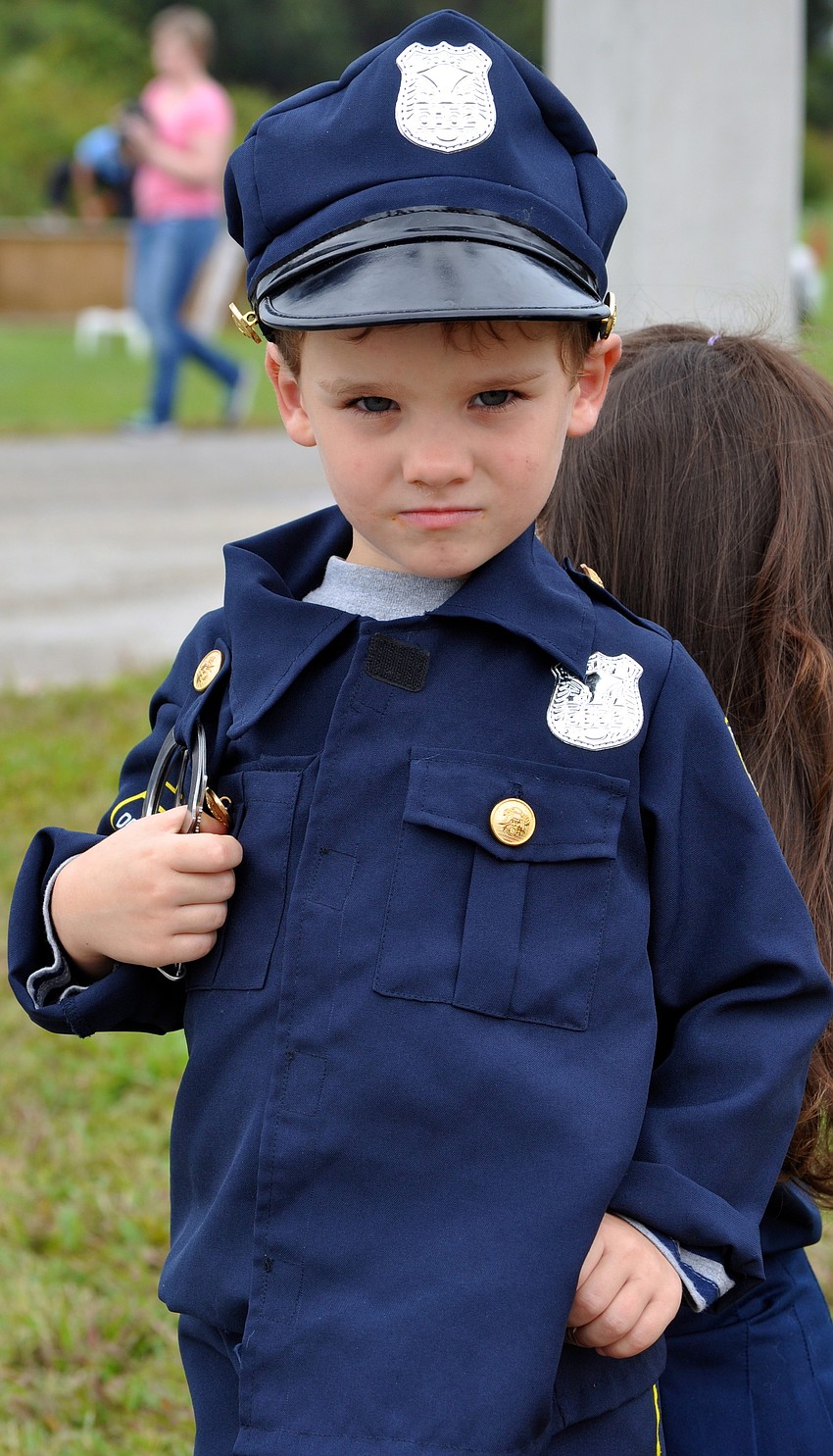 Four-year-old Bobby Peters shows his police pride as he watches the law enforcement relay.