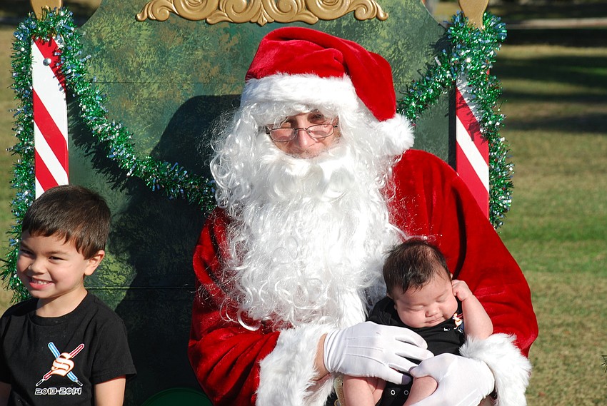 Zack Harshman and baby brother Carter sit with Santa