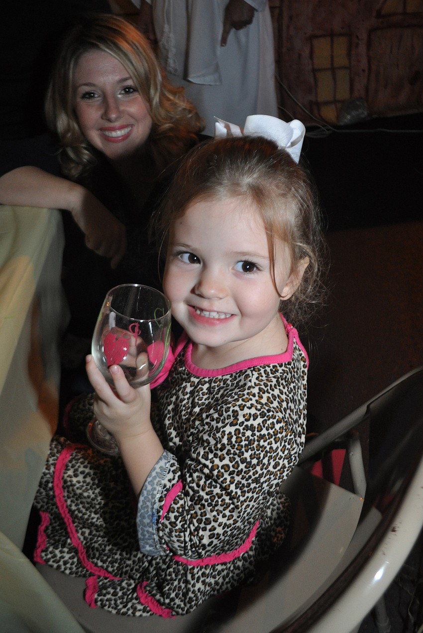 Lorelai Kelley, picture with her mom, Janeen, behind, decorates a wine glass for her grandfather.