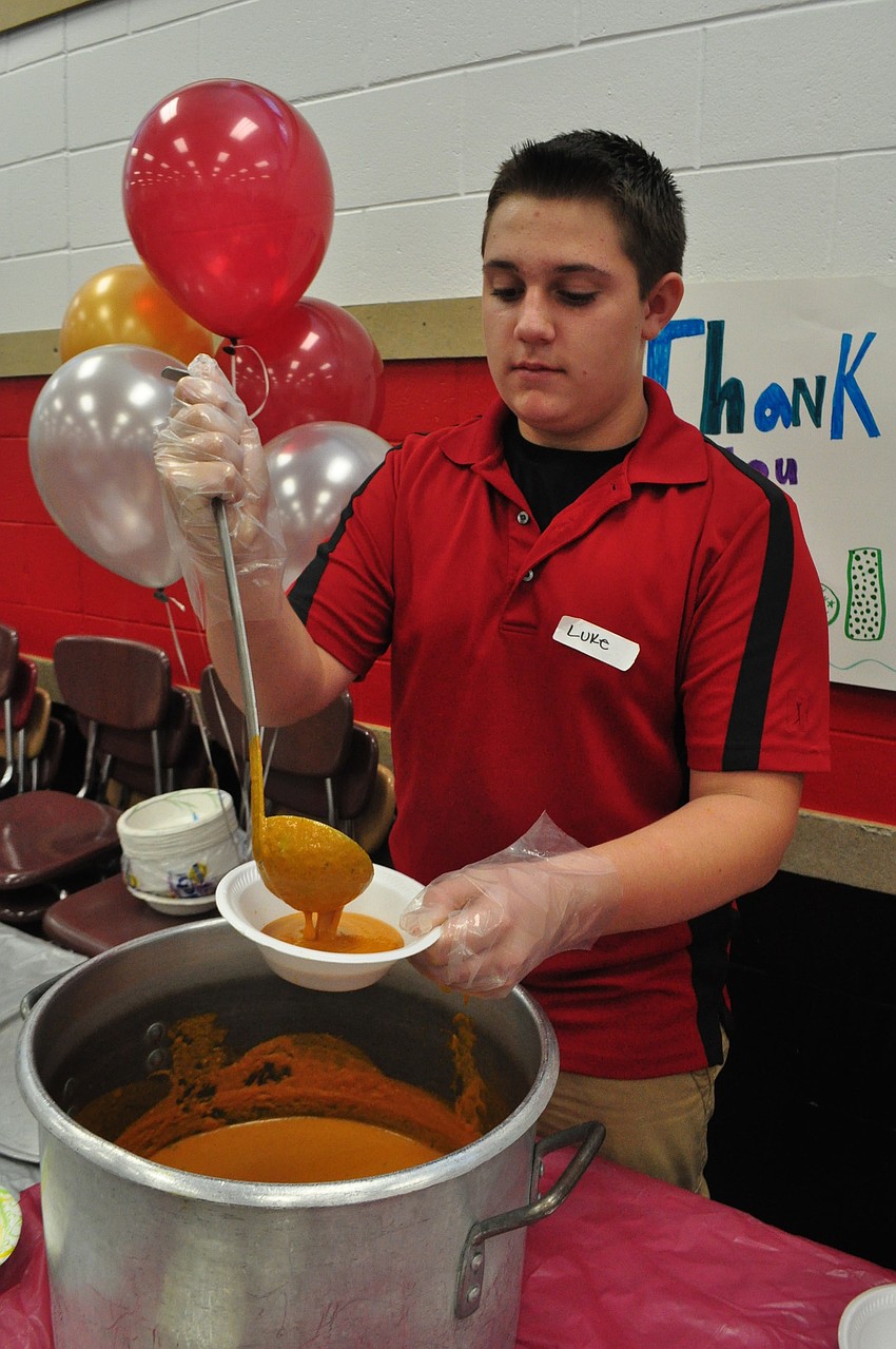 Luke Andrews, 13, ladles tomato-basil soup donated by Crispers.