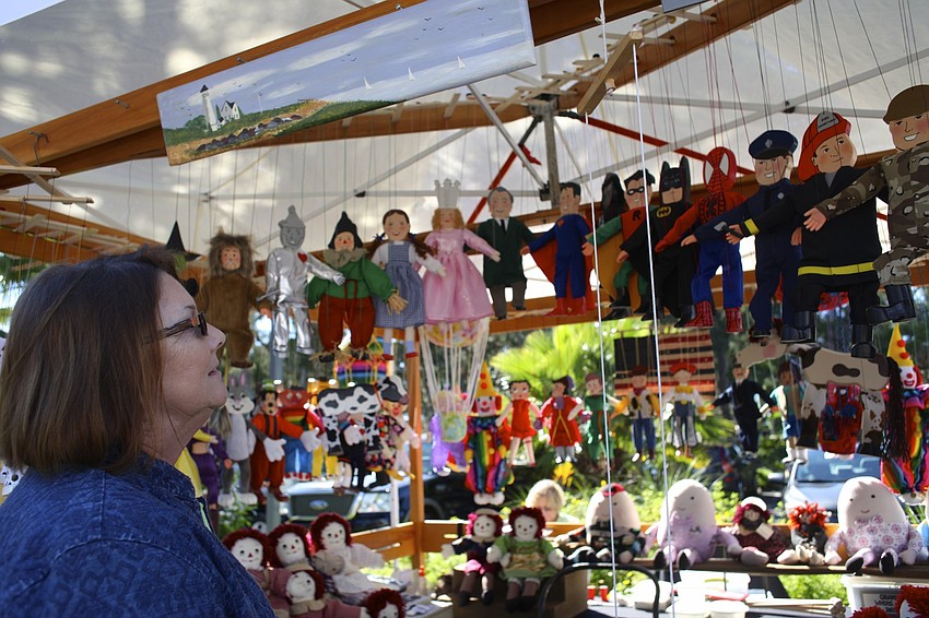 Cindy Hayworth looks at puppets at a festival booth