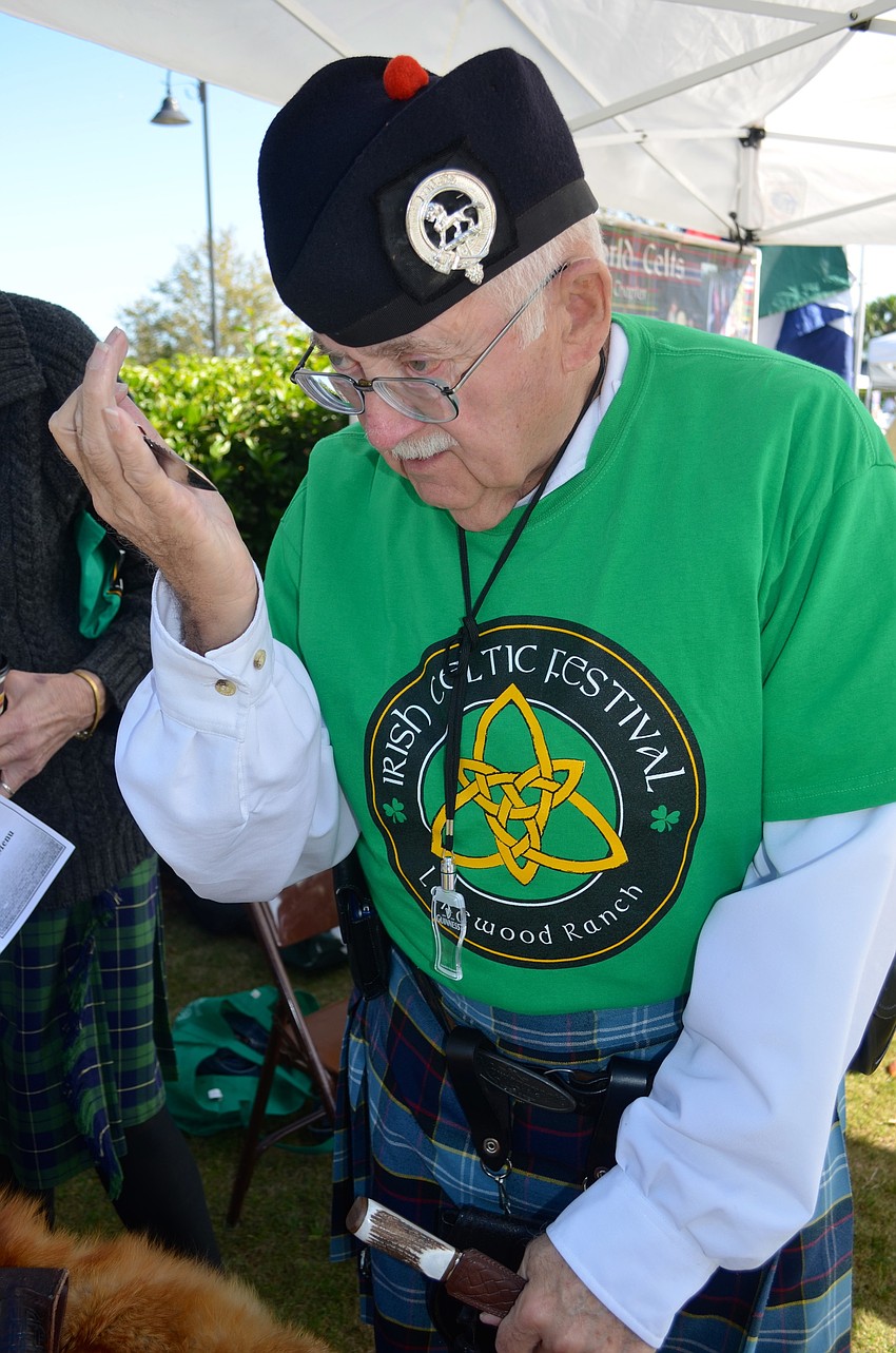 â€” Bob Green, of New World Celts, looks over a weapon used in Scotland.