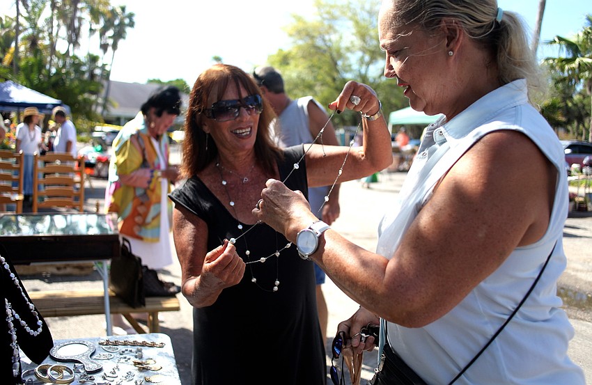 Pam Bernstein helps Caroline Skelton-Goodman pick a necklace from her booth.