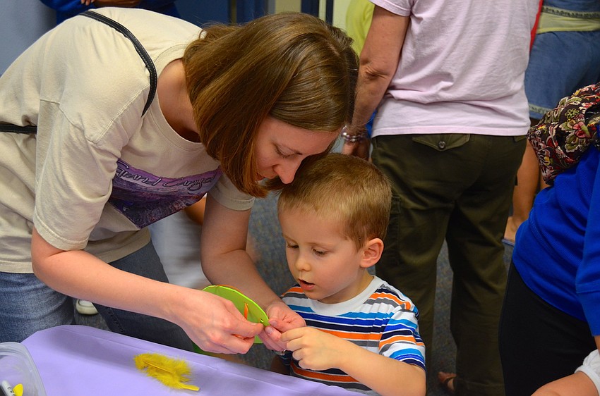 Emily Gould shows her son, Michael, how to decorate a foam Easter egg.