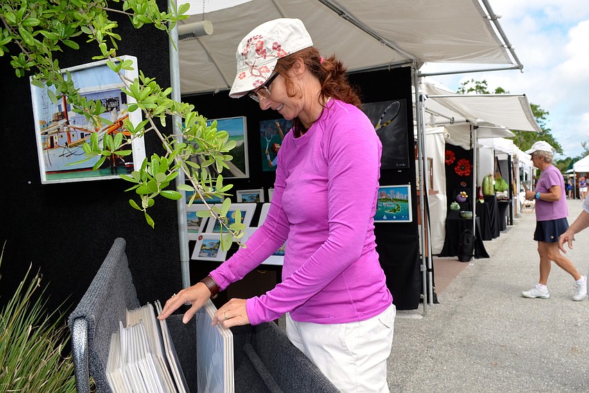 Sandy Young looks through prints at Robert Johnsonâ€™s booth.