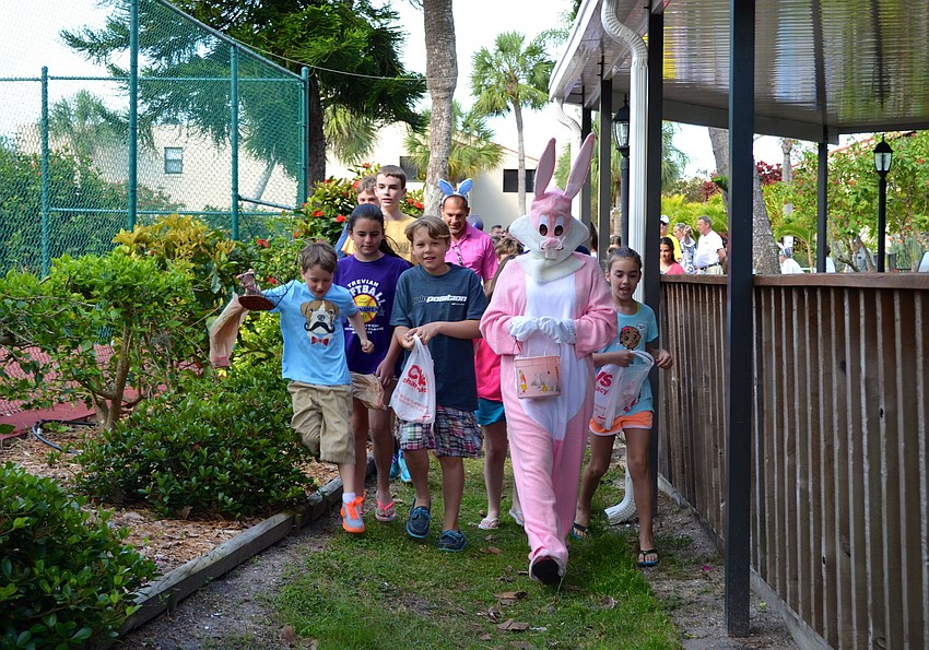 The Easter Bunny leads the children to the egg hunt.