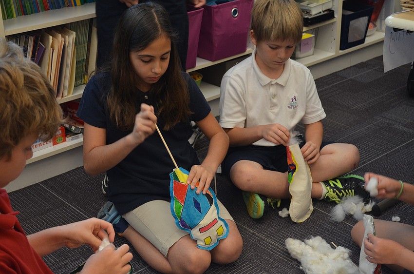 Melina Mallaiaras and Reece Benson stuff their dolls.