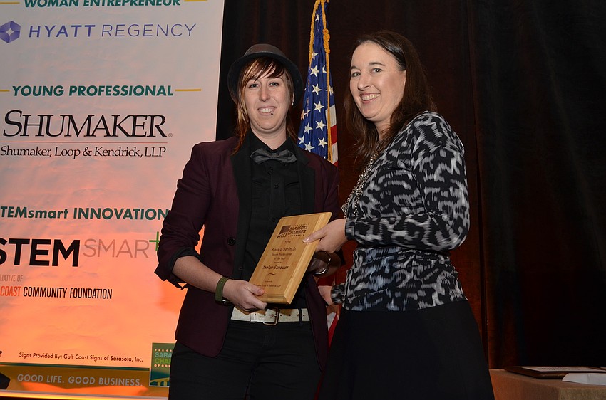 Jennifer Compton of Shumaker, Loop & Kendrick, LLP presents Taelor Scheuer of Cutting Loose Salon with the Young Professional of the Year Award.