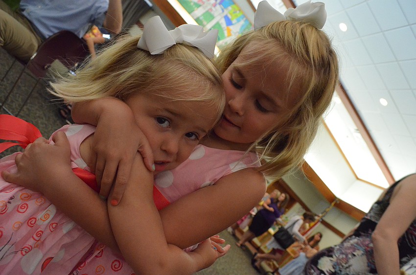 Emerson Miller gives her little sister Elle a hug at the Butterfly Ball.