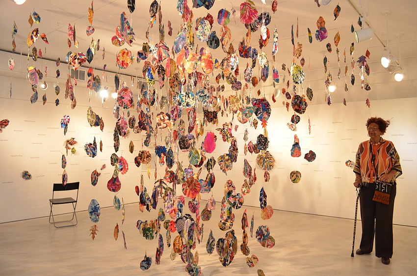 Jackie Peters Cully admiring her installation â€œLeaf | Textile | Purposeâ€ in Gallery 2