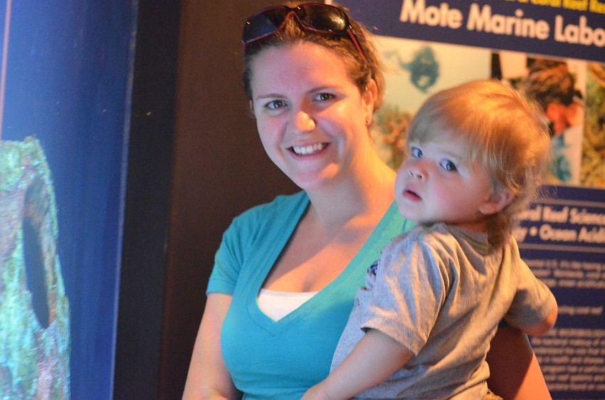 Danielle Carroll and her son Carmen, look at fish in the tank.