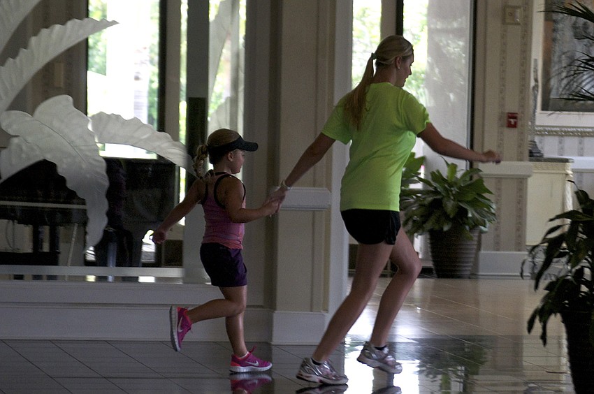 Six-year-old Alexa Gettel runs with camp counselor 17-year-old Megan Falcone