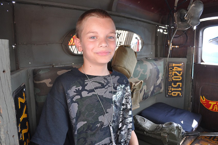 Deacon Marcus, 10, rested in the shade of the '34 international rat rod his father, Matt, built to honor the military.