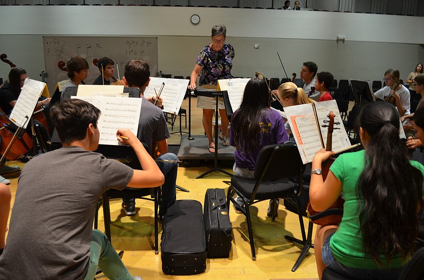 Teacher Valerie Terry instructs the students to write notes in their music.