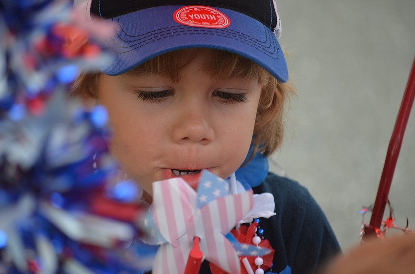 Finn Fluker, 4, tries to get his pinwheel to spin.