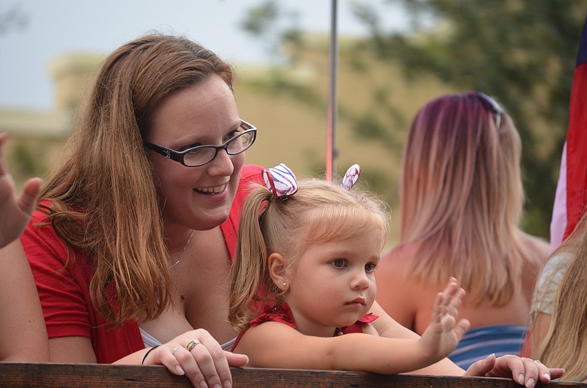 Children and parents wave to the crowd from the boats in the parade.