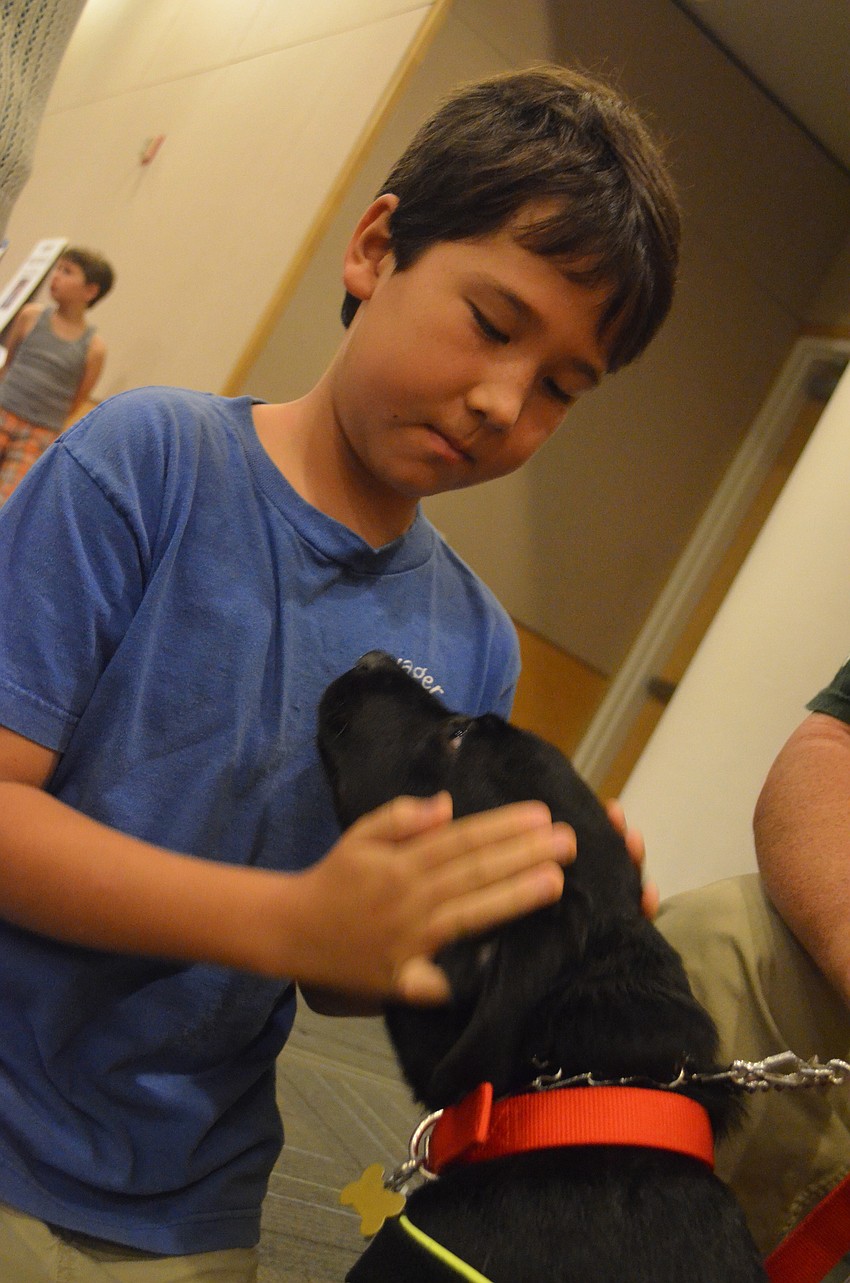 Tsultrim Smith pets black lab puppy Kaleb.