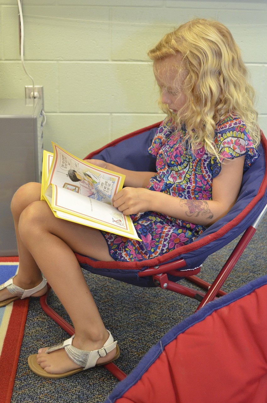 Serena Beaty reads a book in Ms. Pedlerâ€™s classroom.