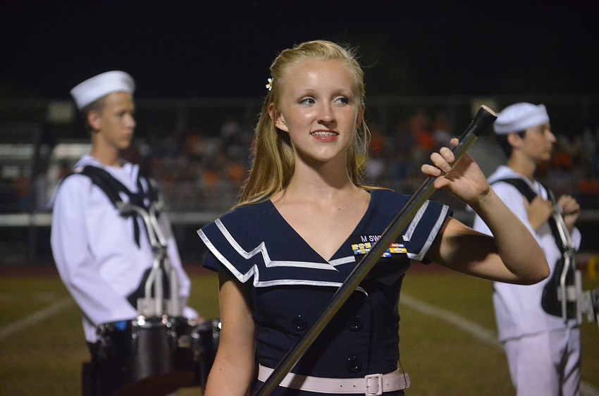 Sarasota High School junior and color guard member Morgan Sweat performs during the half time show.