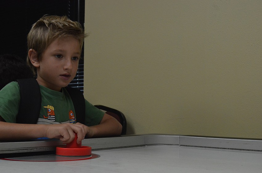 Hayden Stroud, 6, plays air hockey.