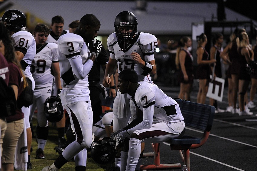 Braden River quarterback Dusty Peebles goes over the game plan with wide receivers Andre Mays and Justin Ross.