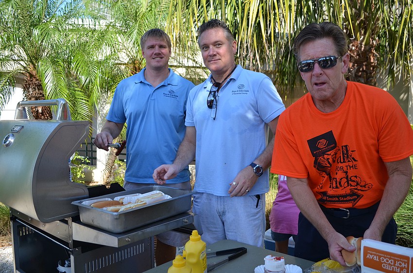 Phillip Hall, Ray Smith and Mike Doyle grill hot dogs for the event.