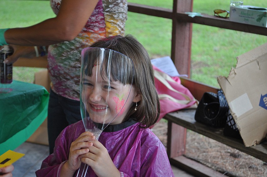 Sarina McCormick gets her hair sprayed with glitter.