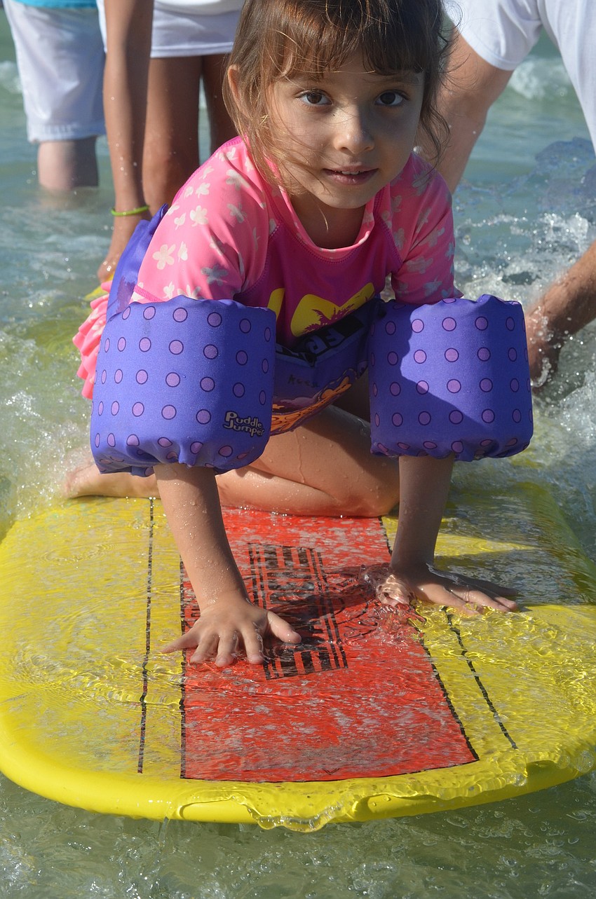 Reese Gurski, 4, tries out the surfboard.