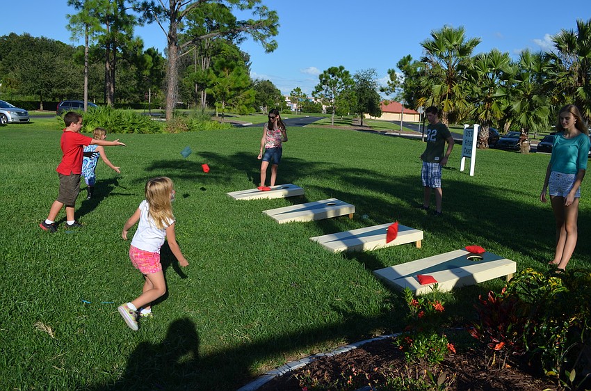 Children test their skills at corn hole.