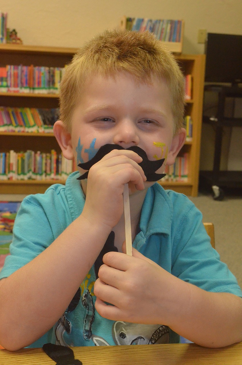 James Beecher, 4, makes a mustache craft.