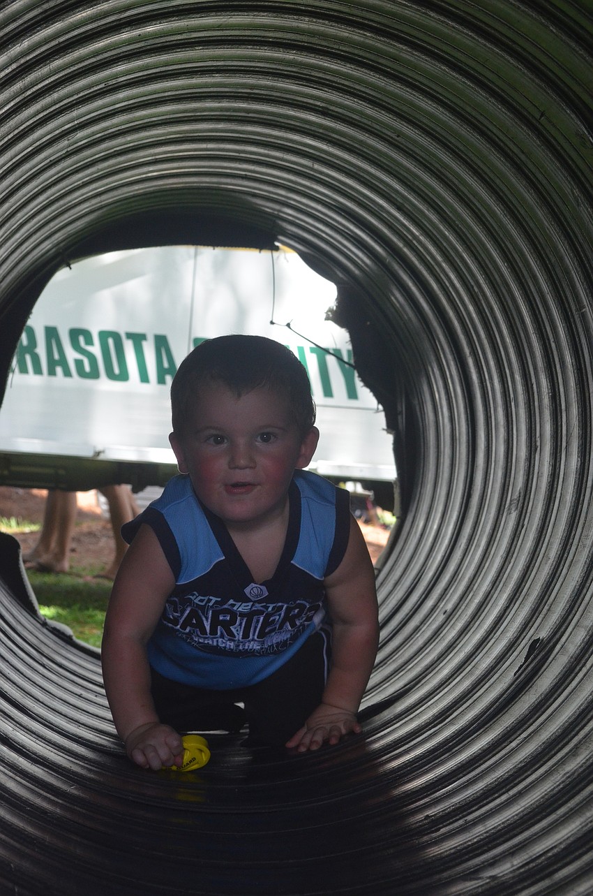 Jaden Coblentz, 2, crawls through the SWAT Combat Challenge.