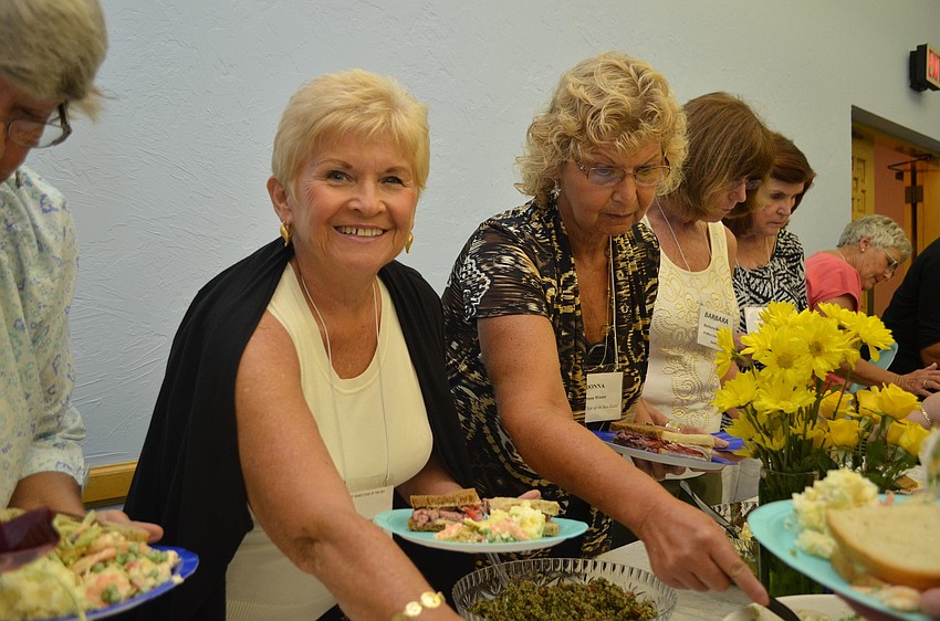 Gerry Sullivan fills her plate with delicious food from the buffet at the Womenâ€™s Guild luncheon.