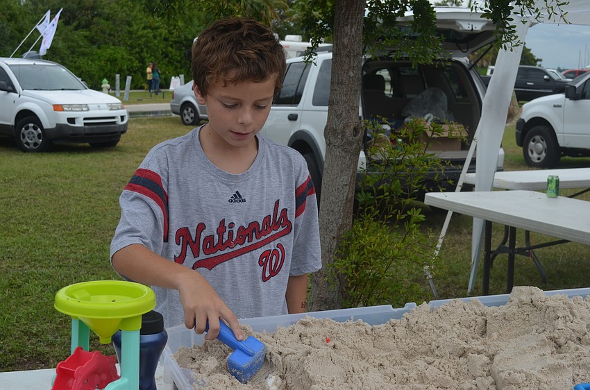 Burke Ryan plays with sand at the HDR booth