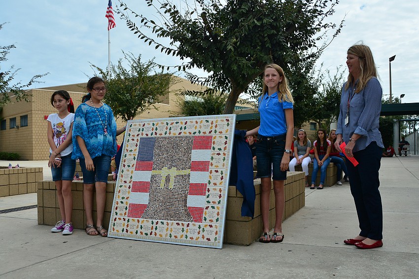 Nicole Rios, Mina Quesen, Courtney Pope and art teacher Heidi Enneking unveiled the schoolâ€™s new tile artwork honoring veterans.