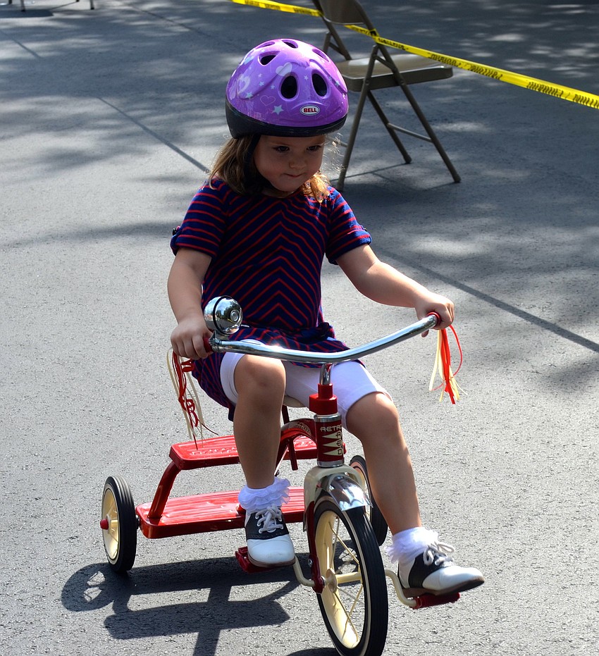 Three-year-old Lorelai Kelley focuses on the pavement ahead.