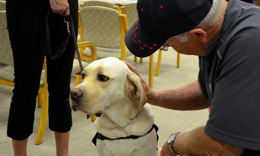 John Sheldon pets Millard before Marjorie Singer speaks