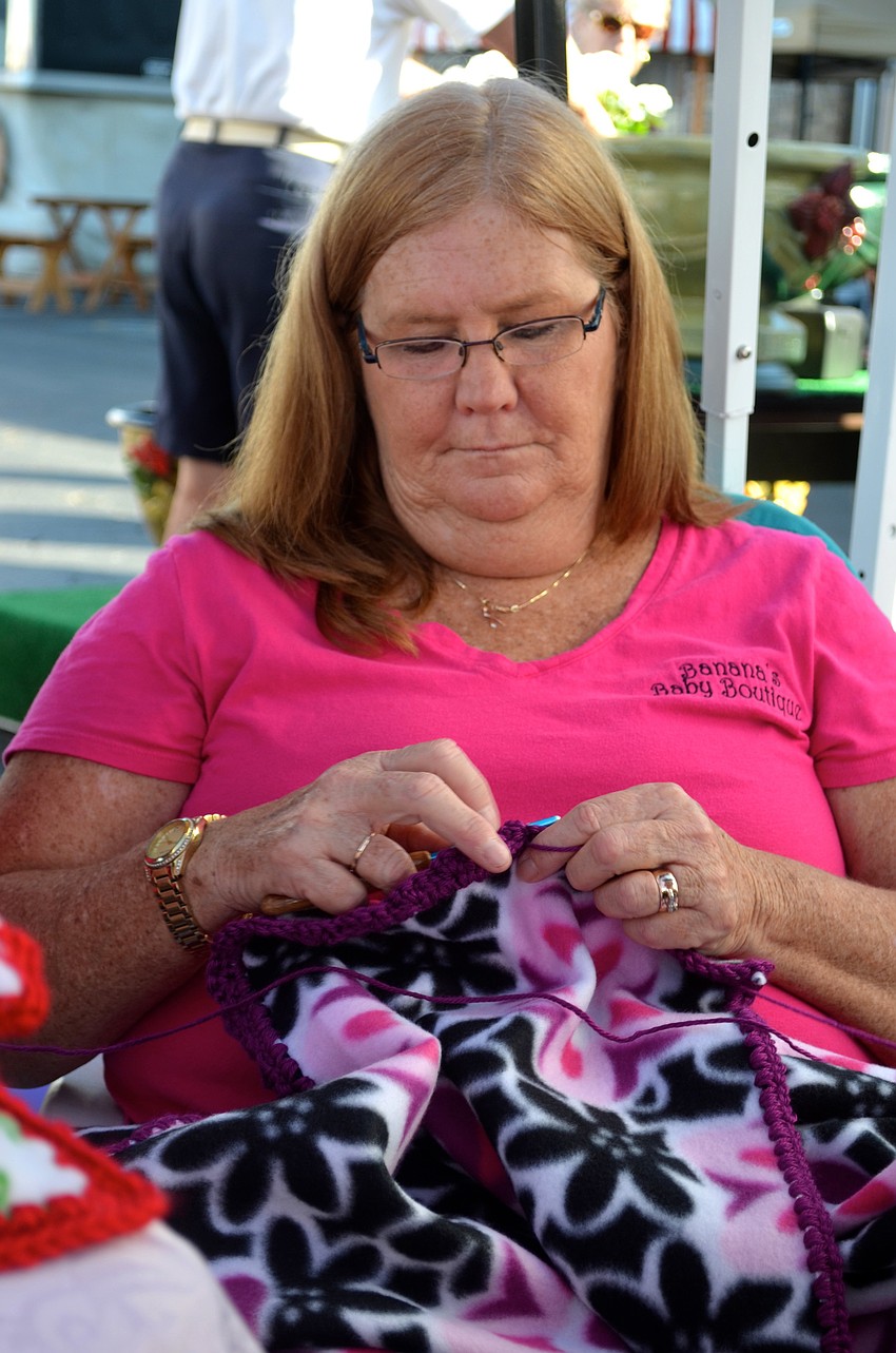 Kathi Seger, owner of Banana's Baby Boutique, keeps busy while waiting for her next customer.