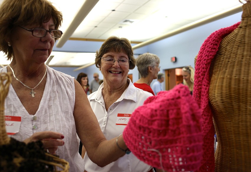 Carole Salmon shows a hat she knitted to Mary McGrath.