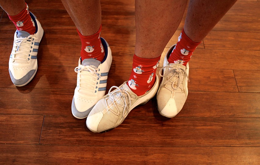Susan Coyne and Michele Kaleida show off their holiday cheer with matching snowmen socks.
