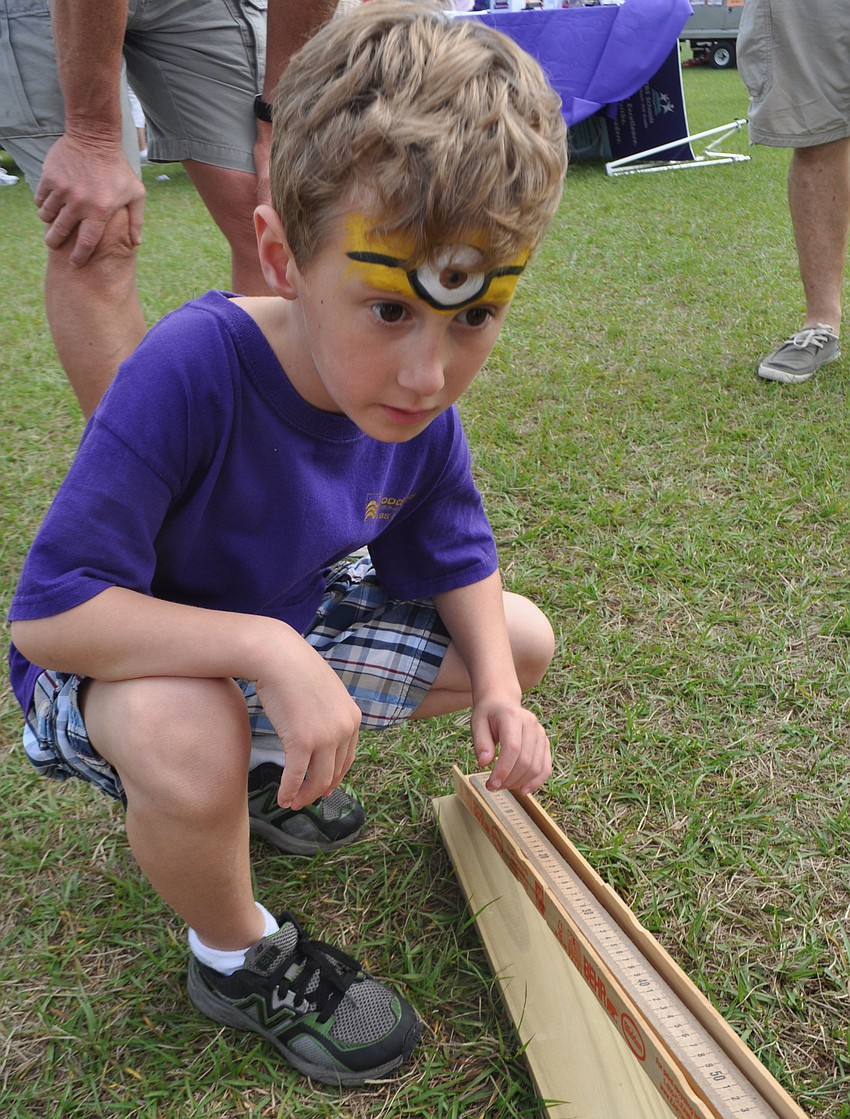 Jesse Gullett, 6, calculates how far a race car will travel.