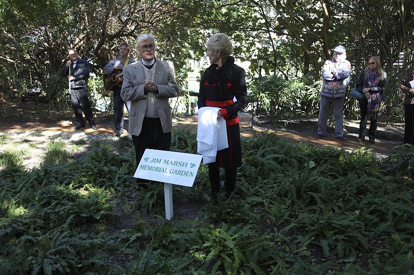 The Rev. Vincent Carroll and Claire Marsh unveil the new sign in the garden.