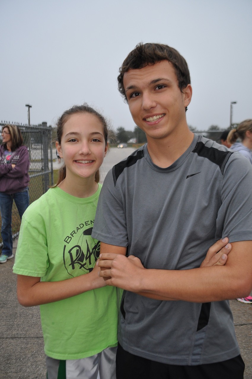 Siblings Madison and Jesse Charbonneau pick up their registration packet.