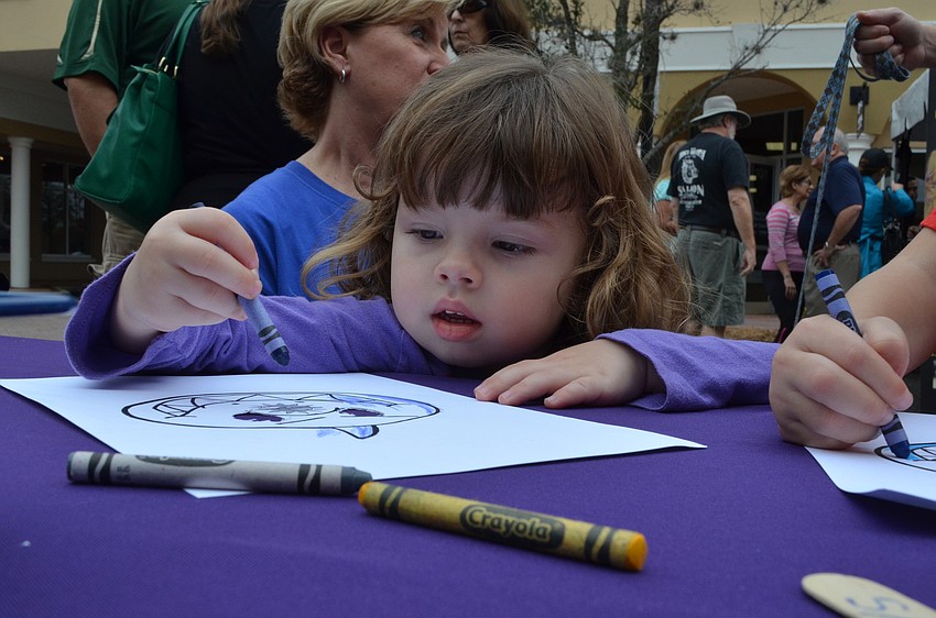 Briana Magrin colors at the Imagine School booth