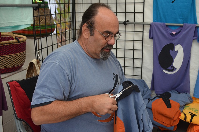 George McLaughlin works on his colorful shirts.