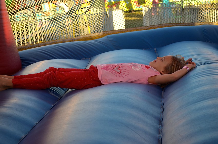 Amelia Raymond, 8, takes a time out in the bounce house.