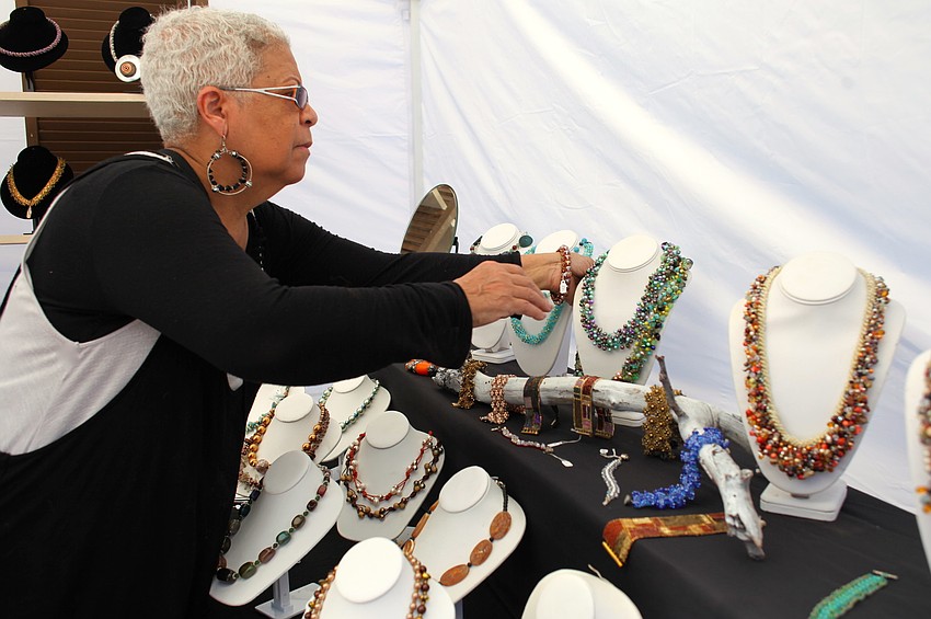 Magda Samson prepares her jewelry booth for festivalgoers.