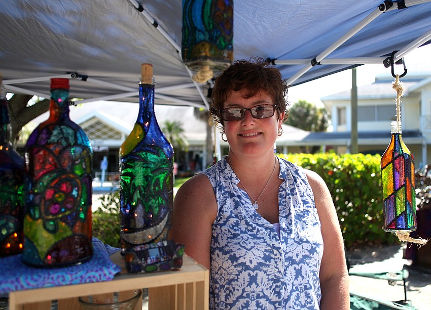 Stacy Hurst poses with her one-of-a-kind painted bottles and vases.